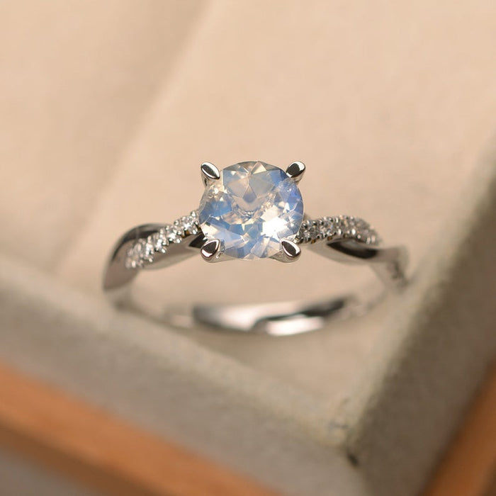 Twisted 1.25 Carat Round Cut Blue Moonstone and Diamond Infinity Engagement Ring in White Gold