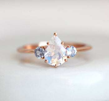 1.10 Carat Pear Shape Rainbow Moonstone and Sapphire Three Stone Engagement Ring in Rose Gold