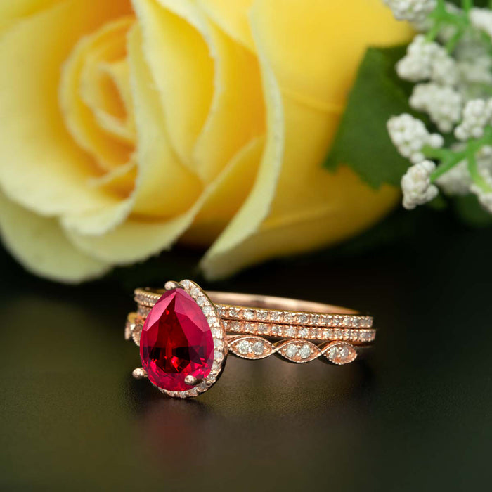 2 Carat Pear Cut Halo Ruby and Diamond Ring with 2 Classic Wedding Bands in 9k Rose Gold