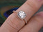 1.50 Carat Round Cut Moissanite and Diamond Halo Engagement Ring in Rose Gold